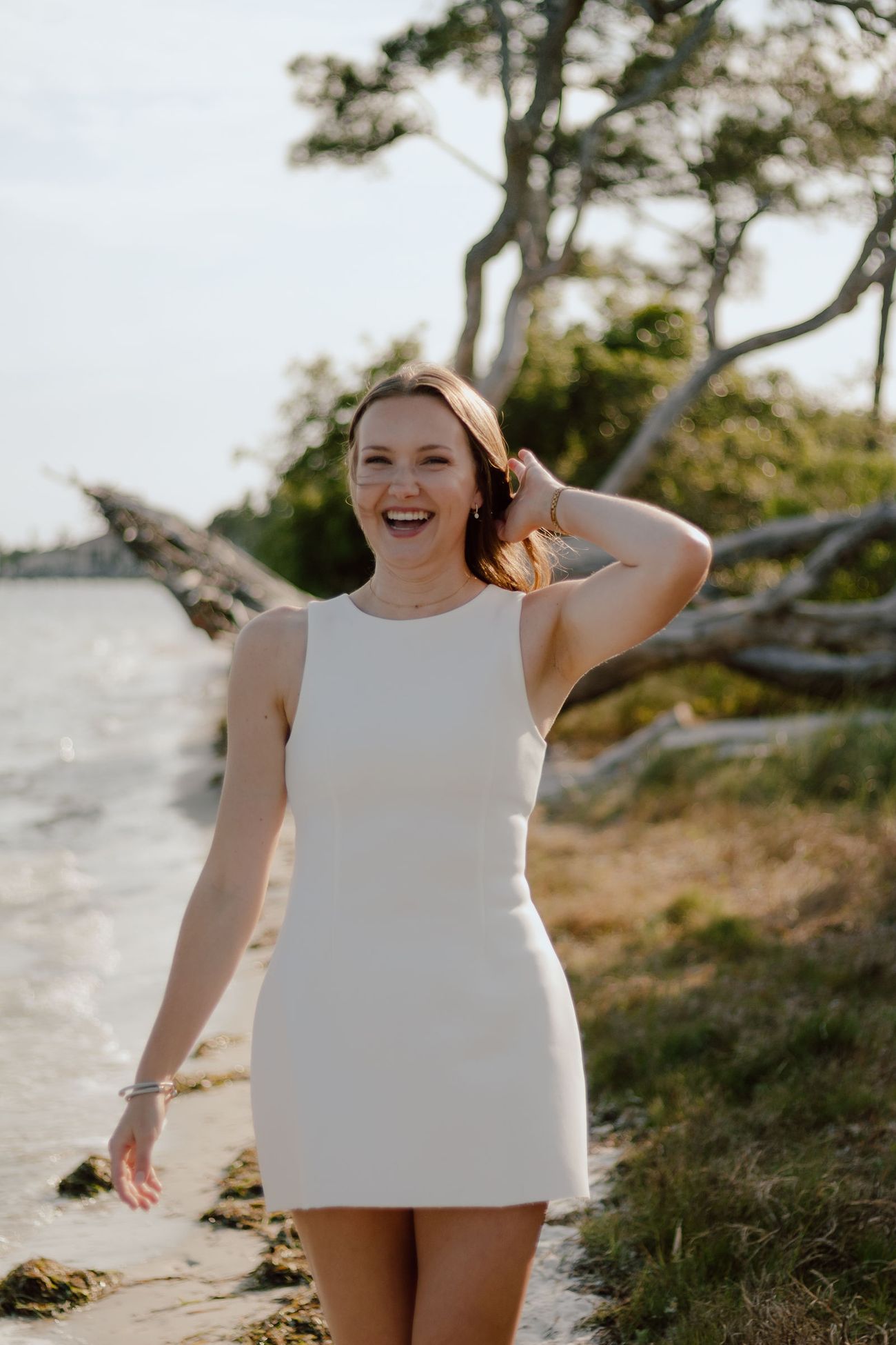 Morgan on the sand with the driftwood behind her