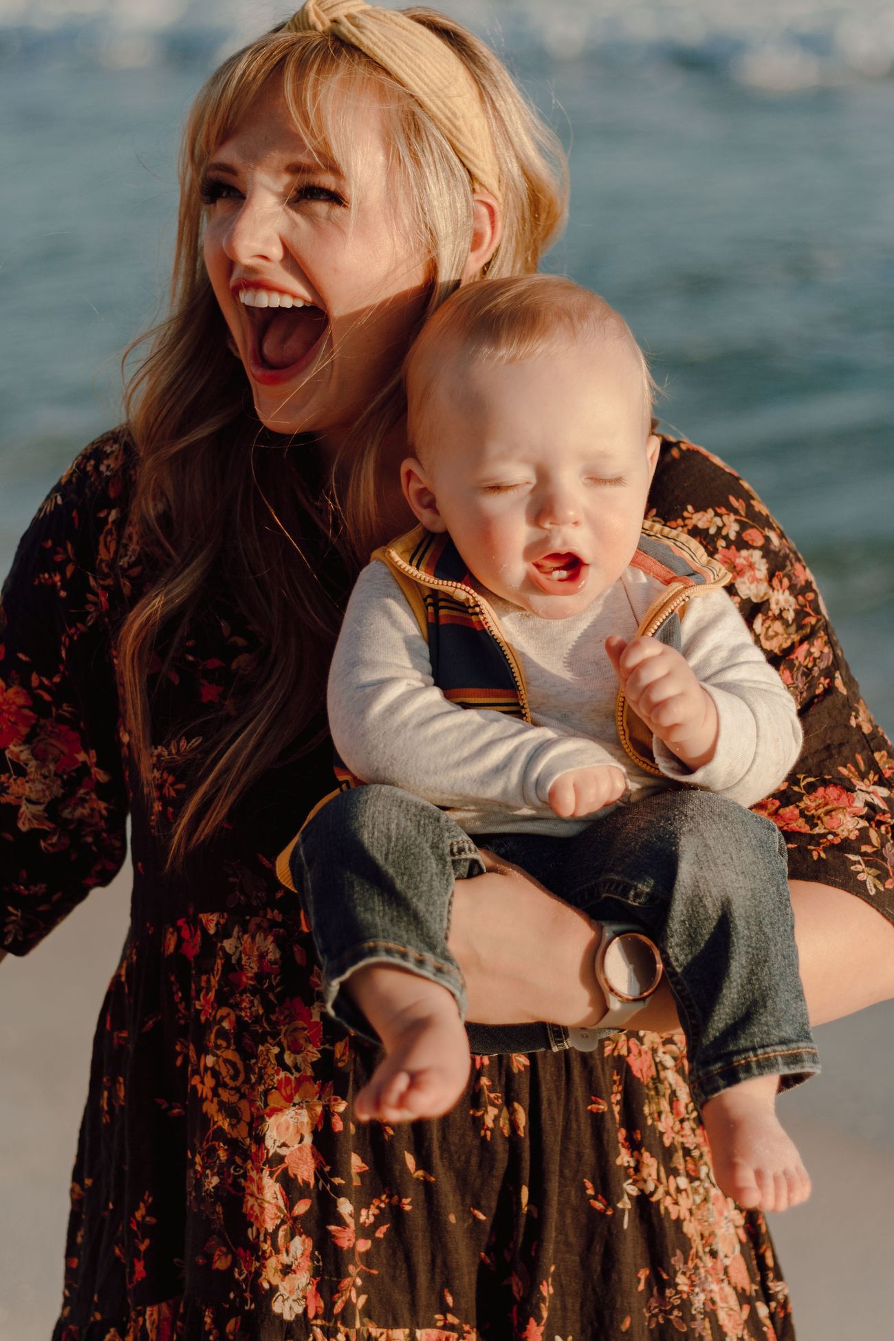 Mom laughing with her baby on her hip